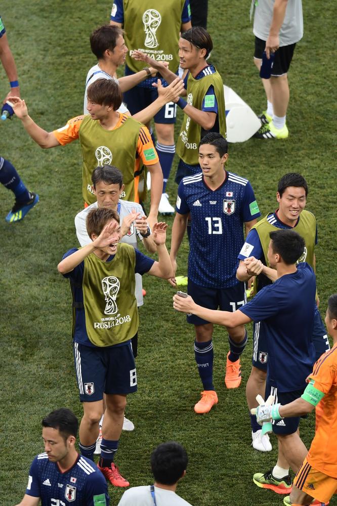 Japan players celebrate after hearing the result of the Senegal and Colombia match will see them progress in the competition after the final whistle of the Russia 2018 World Cup Group H football match between Japan and Poland at the Volgograd Arena in Volgograd on June 28, 2018. / AFP PHOTO / NICOLAS ASFOURI / RESTRICTED TO EDITORIAL USE - NO MOBILE PUSH ALERTS/DOWNLOADS