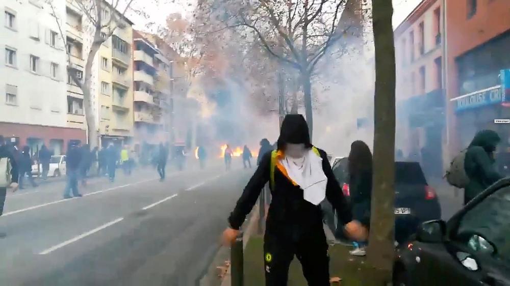 REFILE - CORRECTING INFORMATION A man wearing a mask is seen as youth and high-school students protest against high-school plan reforms, in Toulouse, France December 4, 2018 in this picture obtained from a social media video on December 5, 2018. VIDEOS OBTAINED BY REUTERS/via REUTERS THIS IMAGE HAS BEEN SUPPLIED BY A THIRD PARTY. MANDATORY CREDIT. NO RESALES. NO ARCHIVES.