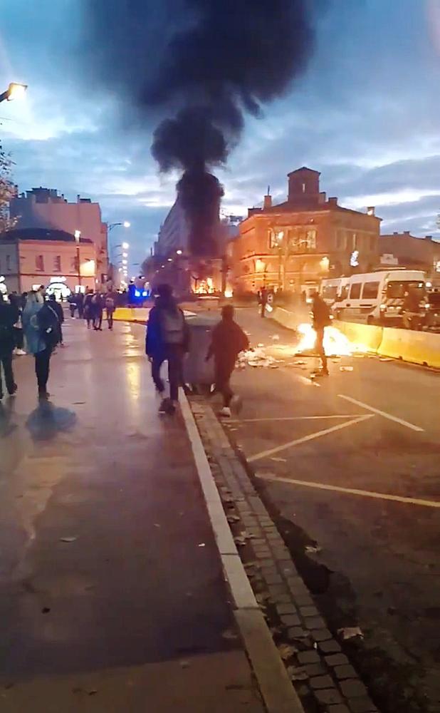 REFILE - CORRECTING INFORMATION People walk near a bonfire as youth and high-school students protest against high-school plan reforms, in Toulouse, France December 4, 2018 in this picture obtained from a social media video on December 5, 2018. Nathalie Gahan/via REUTERS THIS IMAGE HAS BEEN SUPPLIED BY A THIRD PARTY. MANDATORY CREDIT. NO RESALES. NO ARCHIVES.