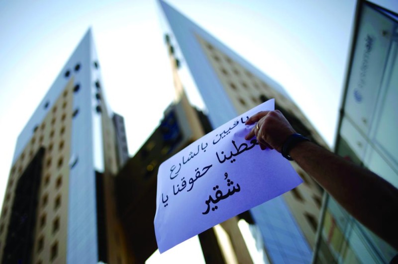 
محتج يحمل لافتة خارج إحدى شركات الهاتف المحمول