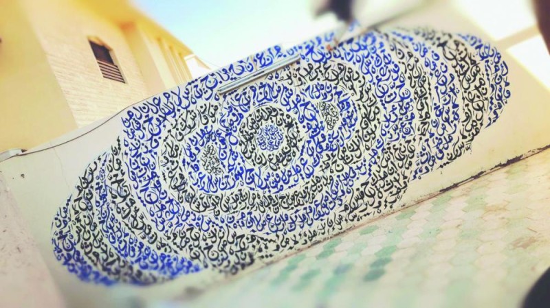 فنان يصنع جدارية بالخط العربي في منزله