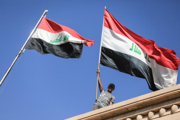 أحد المتظاهرين يلوح بالعلم العراقي خلال مظاهرة - رويترز
