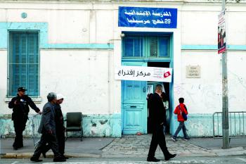 مواطنون توانسة يسيرون قبالة مركز اقتراع بالعاصمة - د ب أ