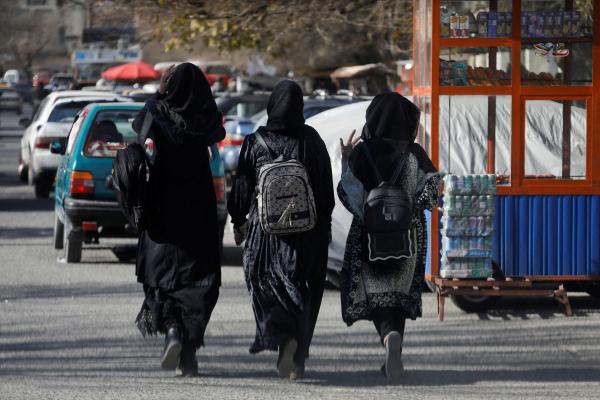 طالبات أفغانيات يسرن بالقرب من جامعة كابول - رويترز