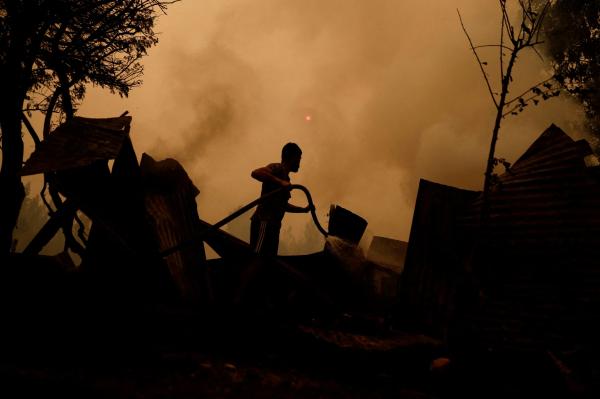 أحد السكان يحاول إخماد حريق في سانتا جوانا بتشيلي - رويترز