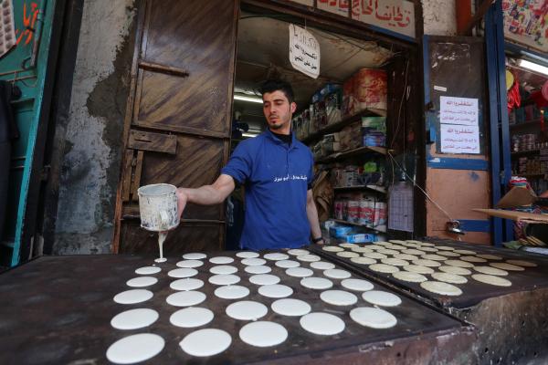 شاب فلسطيني يصنع «القطائف» في غزة (د ب أ)