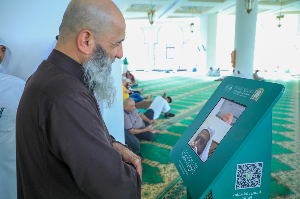 أحد المعتمرين يستخدم خدمة الاتصال المرئي