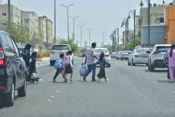 طلاب يمرون من خلال السيارات