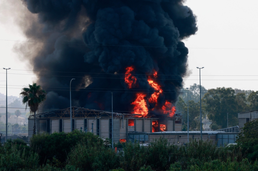 تصاعد الدخان من حريق في مبنى في هرتسليا قرب تل أبيب، إثر وابل جديد من الصواريخ الإيرانية - أ ف ب 