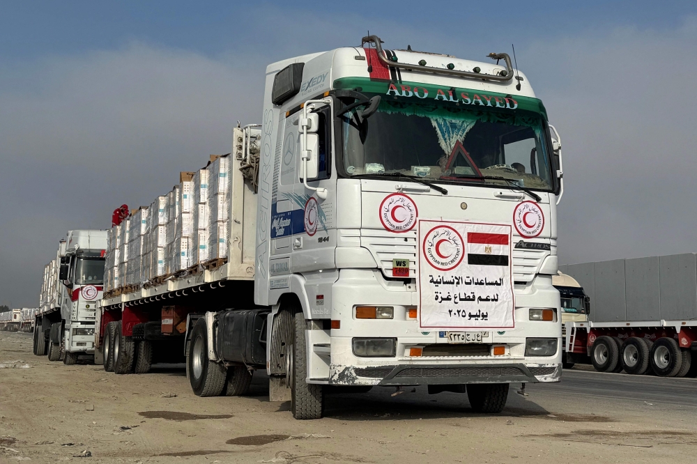 شاحنات تحمل مساعدات تنتظر العبور من الجانب المصري لمعبر رفح - أ ف ب