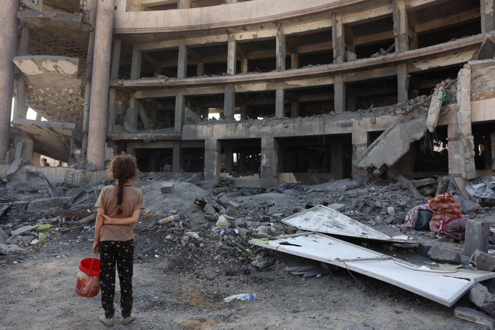 فتاة فلسطينية تتفاعل مع الدمار الذي خلفته غارة ليلية في غزة - أ ف ب