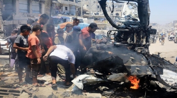 فلسطينيون يتفقدون آثار قصف الاحتلال مركبة في خان يونس جنوب قطاع غزة - وفا