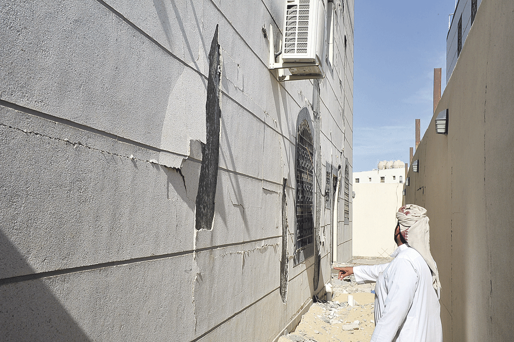 متضرر يشير إلى تشققات المبنى من الخارج (تصوير: طارق الشمر)