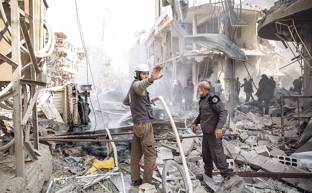 «الخوذ البيضاء» يخمدون حريقا عقب غارات جوية للأسد في الغوطة الشرقية (أ.ف.ب)