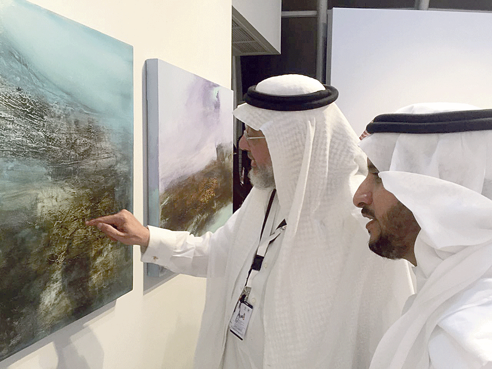 بنجابي يتأمل لوحة وبجواره الفنان حسين دقاس (اليوم)
