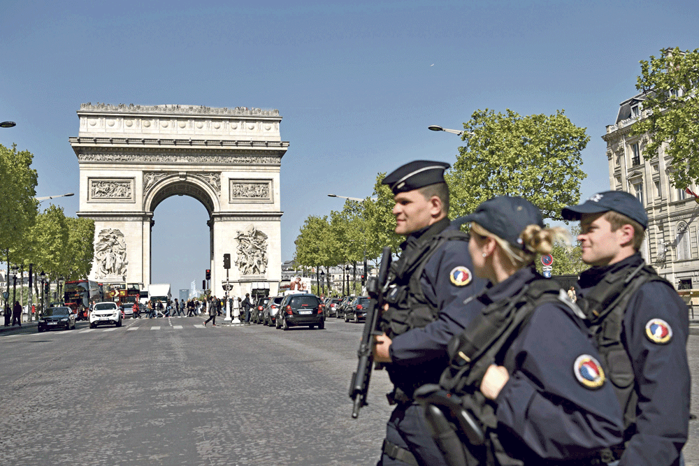 دوريات للشرطة بشارع الشانزليزيه بالقرب من قوس النصر في باريس (أ.ف.ب)