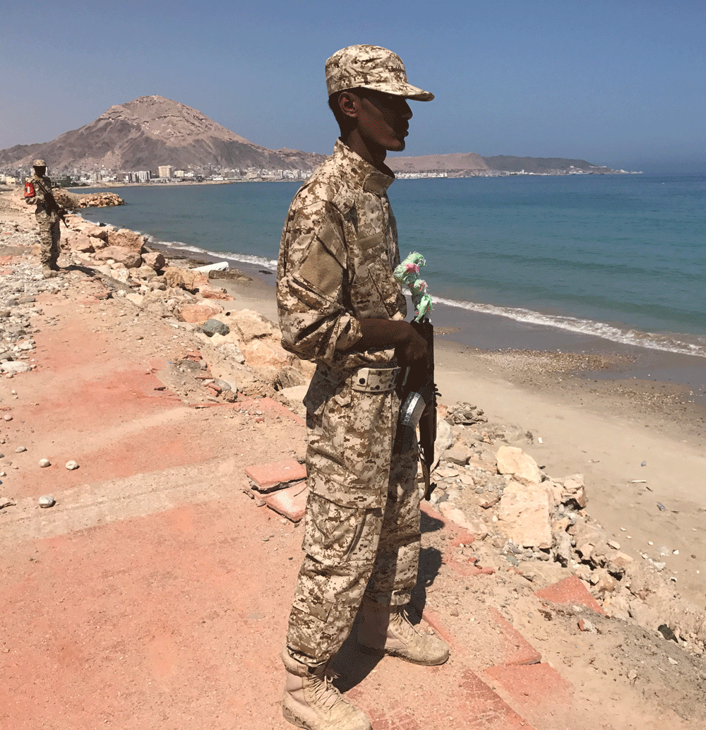 جندي يمني يقف حارسا على شاطئ بمدينة المكلا في جنوب البلاد (رويترز)