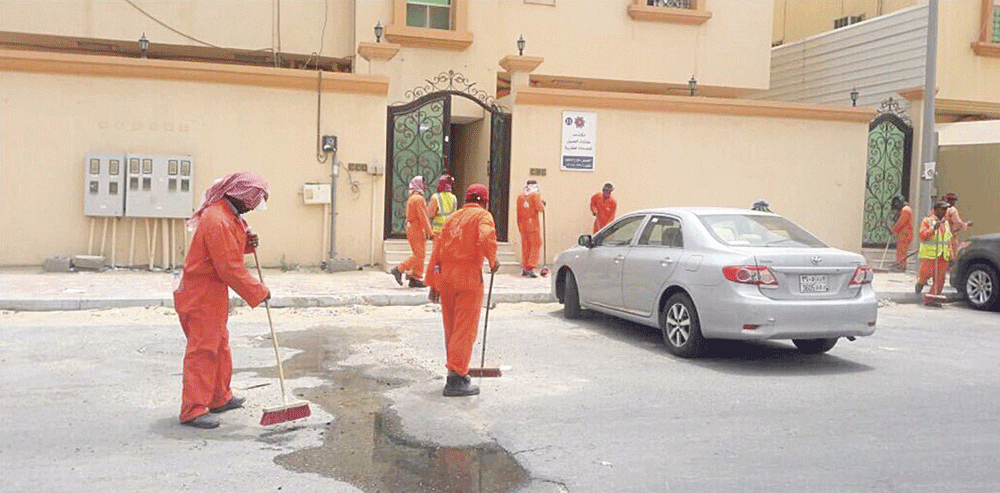 عمال نظافة ينظفون أحد الأحياء (اليوم)