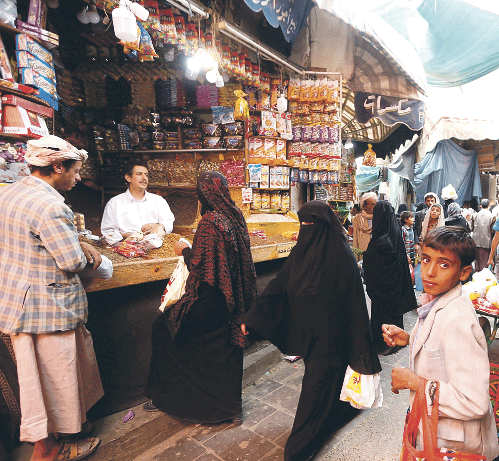 يمنيون يشترون حاجيات قبل وجبة الإفطار من سوق في العاصمة صنعاء (أ.ف.ب) 