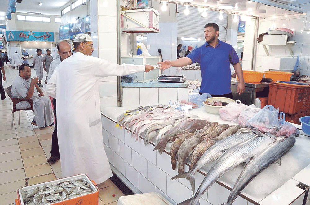 متسوق يشتري كمية من الأسماك أمس (تصوير: مرتضى بو خمسين)
