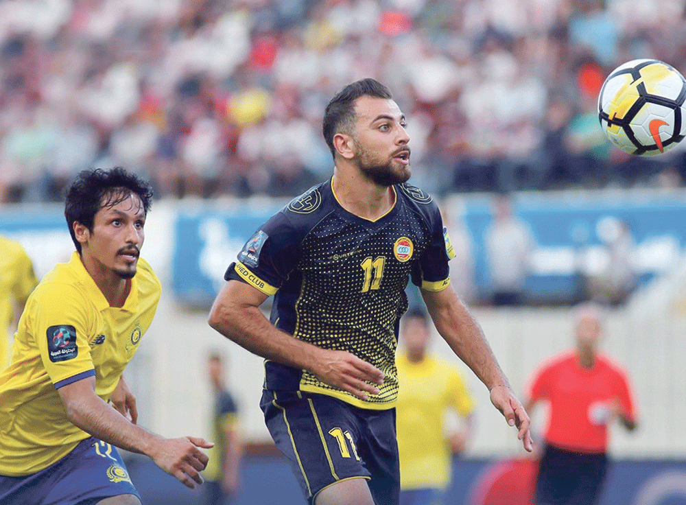 مدافع فريق النصر خالد الغامدي يطارد الكرة وسط مضايقة دفاعات فريق العهد اللبناني (اليوم)