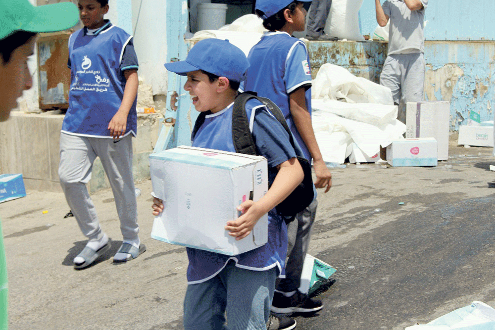 طفل يحمل كرتونة مياه في طريقه لتوزيعها (اليوم)