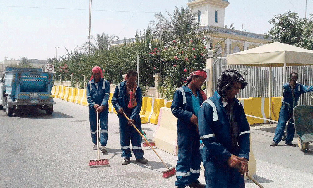 عمال يقومون بتنظيف الشوارع (اليوم)