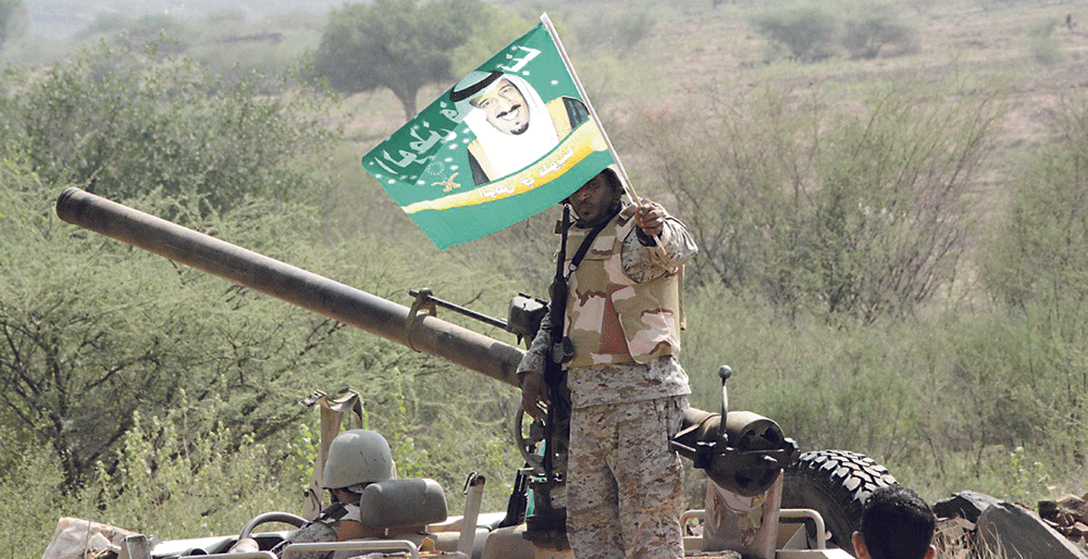 جندي بالحد الجنوبي يحمل صورة خادم الحرمين (اليوم) 