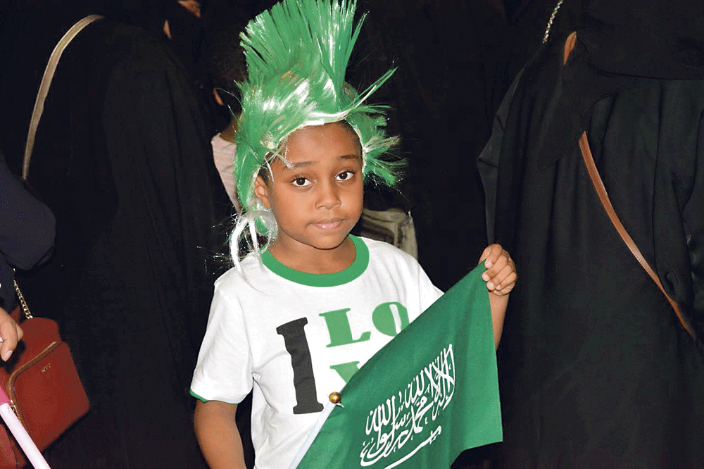 طفل يحمل أعلام الوطن بكل فخر (اليوم)