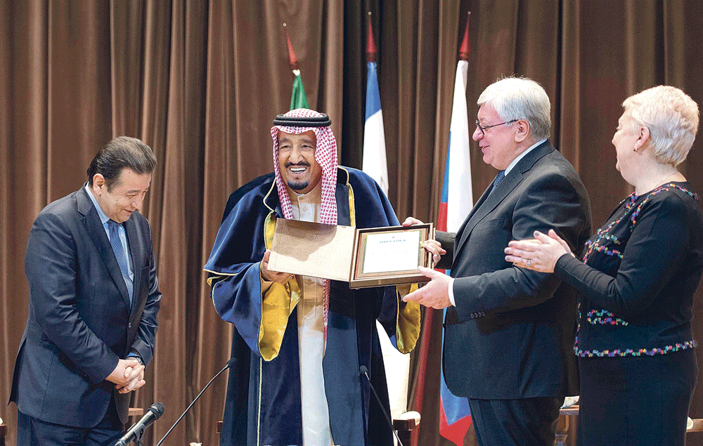 الملك سلمان متسلمًا الدكتوراة الفخرية من مدير الجامعة في حضور وزيرة التعليم (واس)