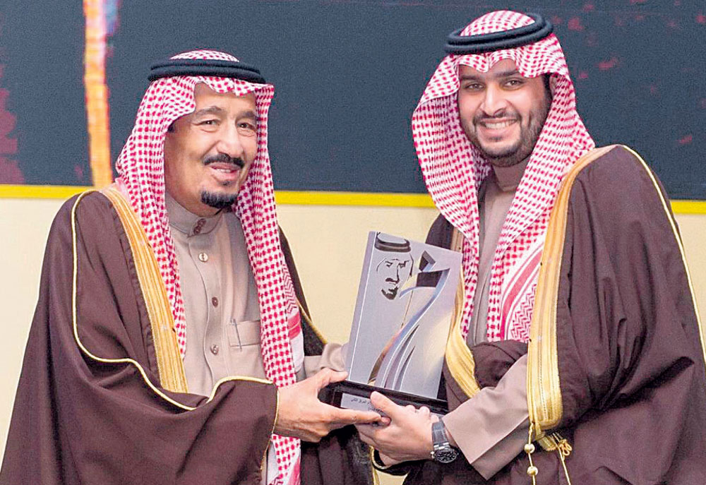 الأمير تركي بن محمد متشرفا بتسلم درع تكريم الجمعية من يدي خادم الحرمين الشريفين 